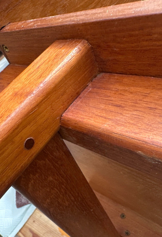 Close-up of the teak cabinet’s carefully fitted leg joint and internal construction.