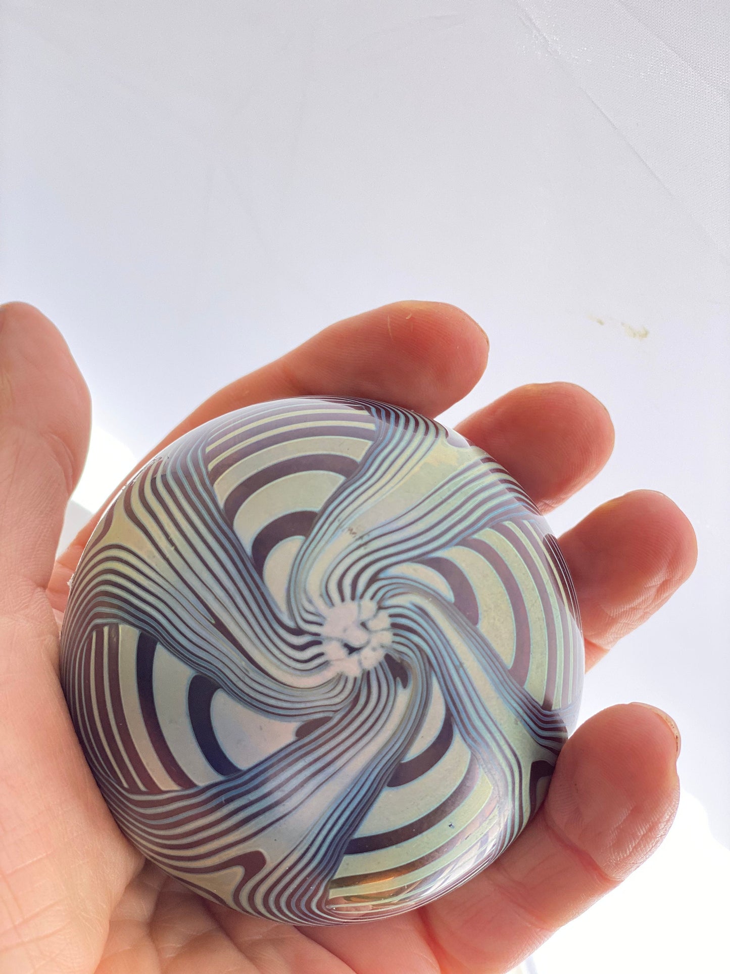 A vintage Okra Studio Glass Blue Black Iridescent Feathered Glass Paperweight by Nicola Osbourne and Richard Golding