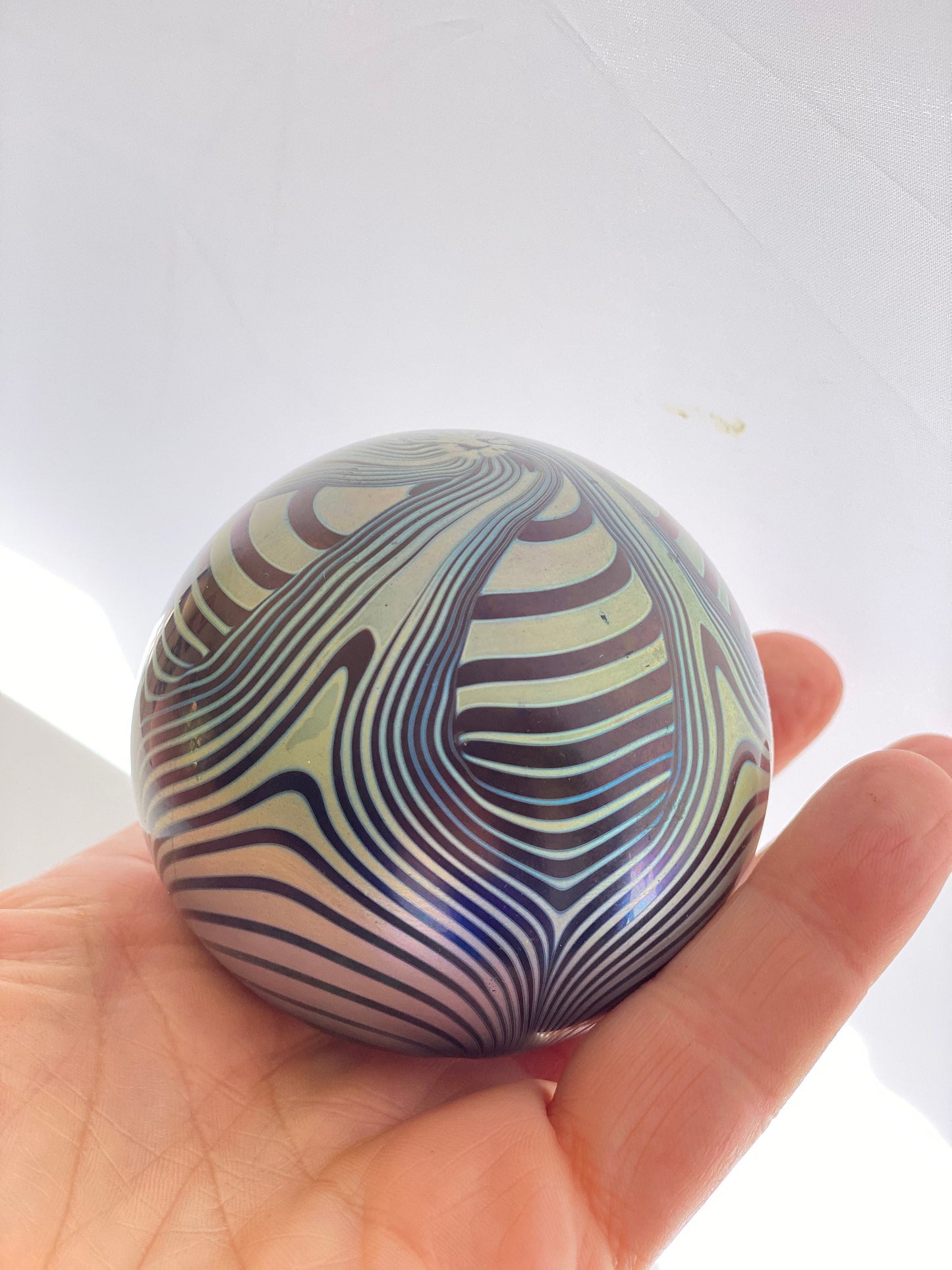 A vintage Okra Studio Glass Blue Black Iridescent Feathered Glass Paperweight by Nicola Osbourne and Richard Golding