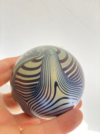 A vintage Okra Studio Glass Blue Black Iridescent Feathered Glass Paperweight by Nicola Osbourne and Richard Golding